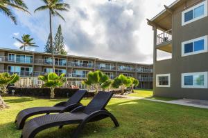 uma fila de cadeiras em frente a um edifício em 2Br Kauai Kailani Condo, Pool, walk to Ocean & Shops, AC KK117 em Kapaa