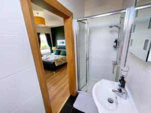 a bathroom with a shower and a sink at Mount Edwards Hill Guest Accommodation in Cushendall