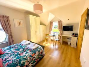 a bedroom with a bed and a desk and a table at Mount Edwards Hill Guest Accommodation in Cushendall