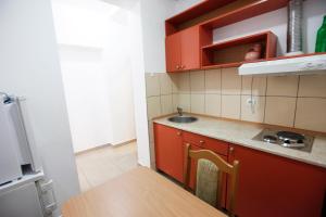 a small kitchen with red cabinets and a sink at Apartments Baron in Sveti Stefan