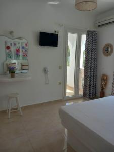 a white room with a bed and a sliding glass door at Klimataria Studios in Agios Prokopios