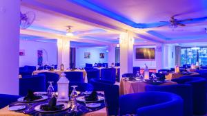 a banquet hall with tables and blue chairs at Hotel Sapphire in Mombasa