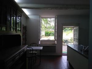 une cuisine avec une fenêtre, une table et des chaises dans l'établissement Ecogîte La charmette, à Suzannecourt