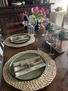 a wooden table with a green plate and wine glasses at Casa di pietra in Castelnuovo di Val di Cecina