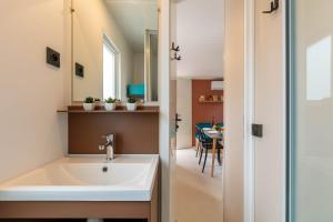 baño con lavabo y comedor en Le Palmier, mobil-home sans vis-à-vis idéalement situé entre mer et vignes, en Hyères