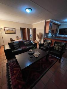 a living room with couches and a coffee table at DullVino Apartment @ Millers Cove in Dullstroom