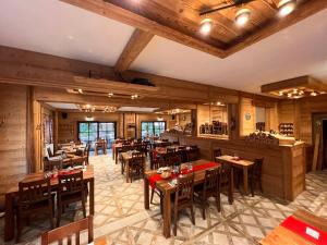 ein Restaurant mit Holzwänden, Tischen und Stühlen in der Unterkunft Hotel Seidl in Straßlach-Dingharting