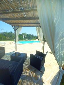 a patio with two couches under a wooden umbrella at Tenuta La Milogna in Gallipoli +26 photos