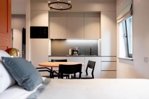 a room with a table and chairs and a kitchen at Hotel Gothards in Kuldīga