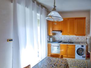 a kitchen with wooden cabinets and a white curtain at Levante home in Trani