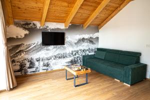 salon z zieloną kanapą i telewizorem w obiekcie Chalets Belianky w Zdziarze