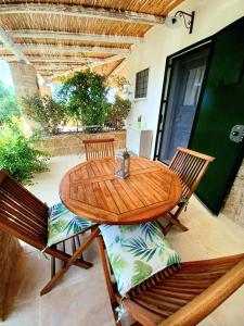 einen Holztisch und Stühle auf einer Terrasse in der Unterkunft Tenuta La Milogna in Gallipoli