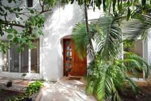 una casa con una puerta de madera y una palmera en 5 Bdr-ensuite Bathrooms-private Pool-golf-comfort, en Cancún