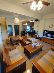 una gran sala de estar con mesas y sillas de madera. en 好心情會館 en Hengchun