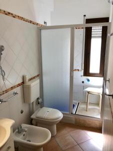 uma casa de banho com um WC, um lavatório e um chuveiro em Tonnara Apartments em Alcamo Marina