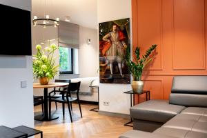 uma sala de estar com uma mesa e um quadro na parede em Hotel Gothards em Kuldīga