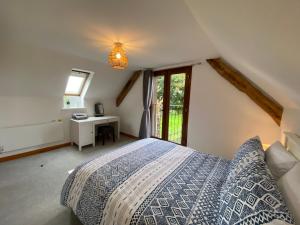 a bedroom with a bed with a desk and a window at Hay Loft in Bideford