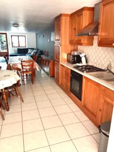 a kitchen with wooden cabinets and a table and a dining room at GÎTE LE GELEINFÊTE II VOSGES à proximité de GERARDMER in Herpelmont