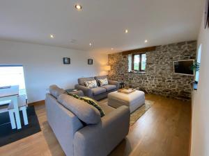 a living room with two couches and a tv at Hay Loft in Bideford