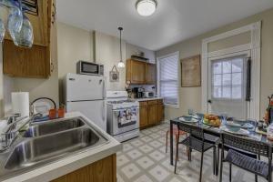 a kitchen with a sink and a refrigerator and a table at Good Energy Early check-in Parking Long Term More in Chicago