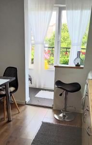 a room with a chair and a table and a window at 33 Coquette Apartment in Baia Mare