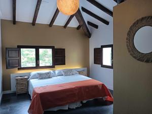 a bedroom with a large bed with a red blanket at 1893 Hotel Boutique in Navajas