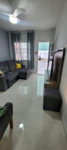 a living room with a couch and a tv at Casa mobiliada recém reformada in Matinhos