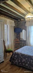 Posada Campo في سوانسيس: غرفة نوم بسرير وكرسي
