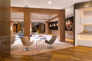 a lobby of a hotel with chairs and tables at NH Collection Berlin Mitte am Checkpoint Charlie in Berlin