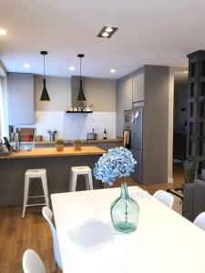 a kitchen with a table with a vase of flowers on it at Gran Terraza, vivienda Única! Muy céntrica in Torrelavega