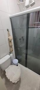 a bathroom with a toilet and a glass shower at Casa mobiliada recém reformada in Matinhos