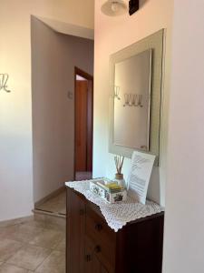 een kamer met een dressoir met een spiegel aan de muur bij Casa AmeRosa in Fiorenzuola di Focara