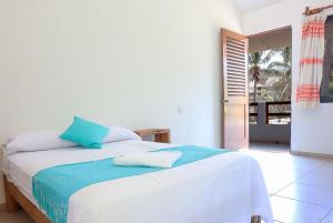 a bedroom with a bed with blue pillows on it at Casa Yoo Bigu Mazunte in Mazunte