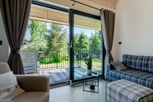 een woonkamer met een bank en een balkon bij Domek w Borze in Kościelisko
