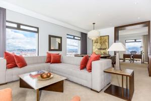 a living room with a white couch and red pillows at NH Collection Bogotá Royal Teleport in Bogotá