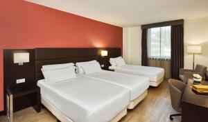 A bed or beds in a room at NH Coimbra Dona Ines