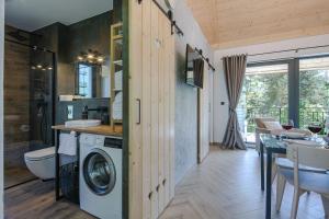 een badkamer met een wasmachine en droger in een huis bij Domek w Borze in Kościelisko