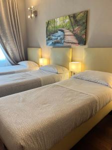 duas camas num quarto com duas lâmpadas em Residenza Segrate Centro Novegro em Segrate