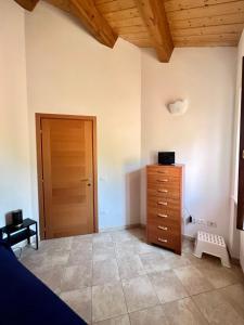 een slaapkamer met een dressoir en een houten deur bij Casa AmeRosa in Fiorenzuola di Focara