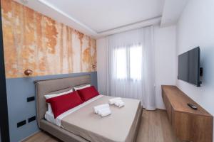 a bedroom with a bed with red pillows and a television at Agata in Galatina
