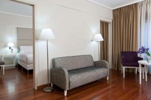 um quarto com uma cadeira, uma cama e um espelho em NH Buenos Aires Florida em Buenos Aires
