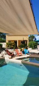 a swimming pool with chairs and a large umbrella at VILLA DEL CIELO TIXPEHUAL in Tixpehual