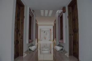 een hal van een gebouw met houten deuren en witte muren bij Hotel Real del Carmen - Ideal para familias y parejas in San Cristóbal de Las Casas