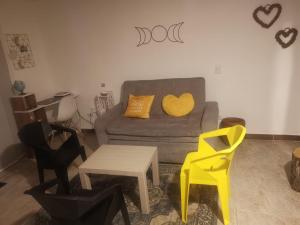 a living room with a couch and two yellow chairs at La Lunar un espacio ideal para trabajar y conocer Medellín in Medellín