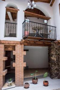 een woonkamer buiten met een balkon en een bakstenen open haard bij Hotel Real del Carmen - Ideal para familias y parejas in San Cristóbal de Las Casas