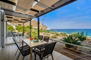 un patio con mesa, sillas y el océano en Marina apartments, en Lentas