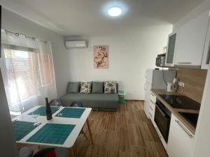 a kitchen and living room with a couch and a table at Apartments Niko Metajna, island Pag in Metajna
