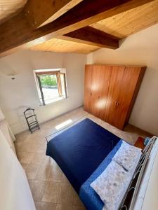 een slaapkamer met een blauw bed in een kamer bij Casa AmeRosa in Fiorenzuola di Focara