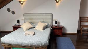 a bedroom with a bed with two pillows on it at Aneto Dúplex en Badaguas in Badaguás