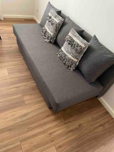 a couch with three pillows on a wooden floor at Apartments In Villa in Poggiomarino
